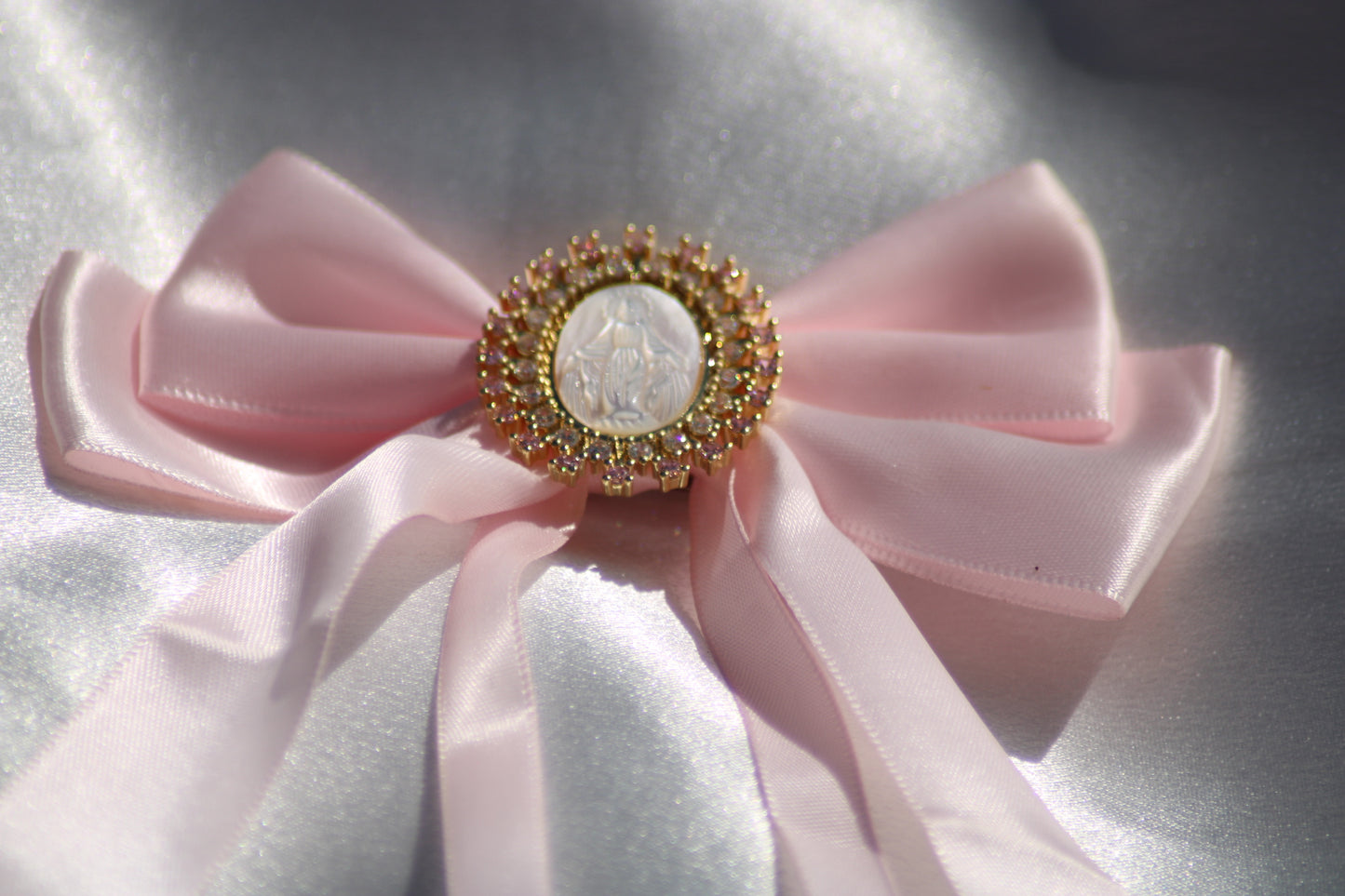 Noeud à cheveux rose avec médaille et strass rose pale